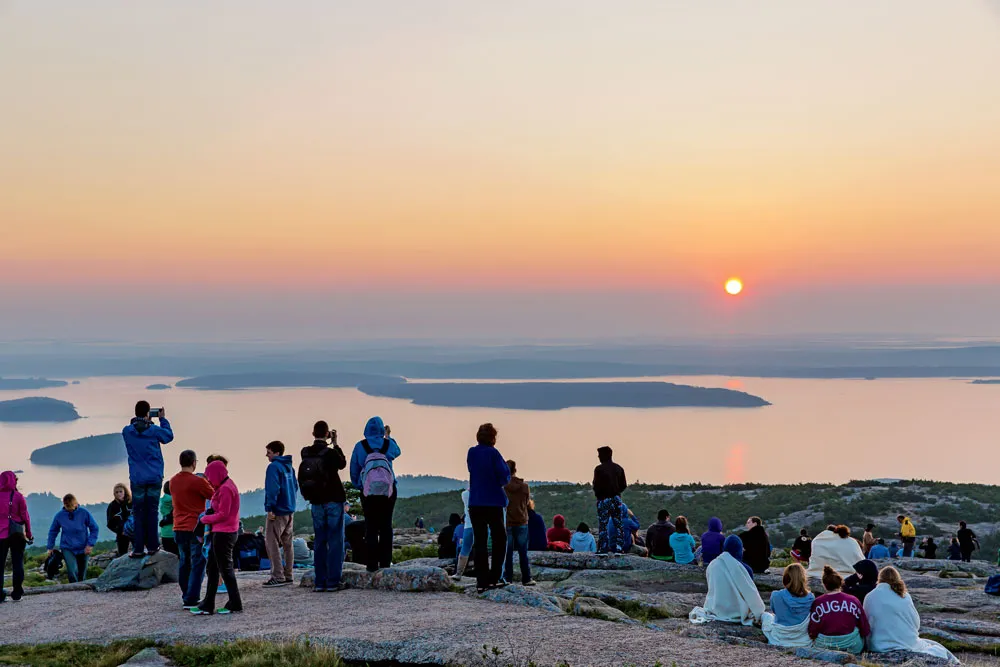 Sunrise on Cadillac Mountain in Acadia National Park showing golden light over rocky summit